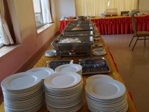 a long table with white plates on it at Seng Aroun Hotel in Pakse