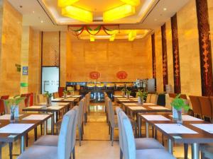 a restaurant with tables and chairs in a room at Shanshui Fashion Hotel Shunde Ronggui Branch in Shunde