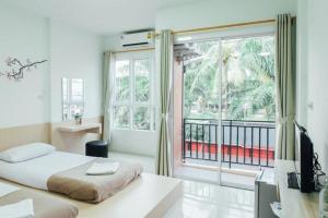 Un dormitorio con una cama y una ventana grande. en Cheaper Room, en Surat Thani