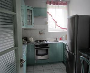 a kitchen with green cabinets and a stainless steel refrigerator at Willa w Ogrodzie in Sandomierz