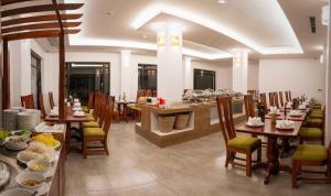 a dining room with tables and chairs with dishes on them at The Palm Hotel in Sihanoukville