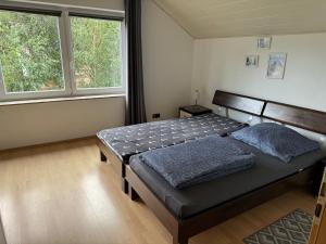 a bedroom with a bed and two windows at Familienferienwohnung in Eckernförde