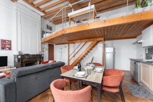 a living room with a couch and a table and chairs at Fenêtre sur cour - Studio pour 2 in Lyon