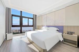 Un pat sau paturi într-o cameră la New Century Mansion Hotel Cixi Guanhaiwei