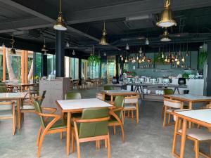 a restaurant with tables and chairs and a bar at Eco Cozy Beachfront Resort Chaam in Ban Tha Sai