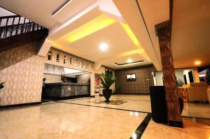 a lobby of a building with a potted plant at Hotel Benteng in Bukittinggi