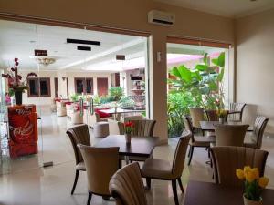 a dining room with tables and chairs in a restaurant at The Margangsa Hotel in Solo