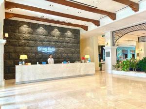 a man standing at a counter in a lobby at Sono Belle Haiphong in Hai Phong +125 photos