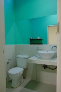 a bathroom with a white toilet and a sink at Matta Lodge Bali in Jimbaran