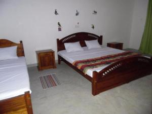 a bedroom with two beds and two night stands at Lagoon Beach Resort in Tangalle