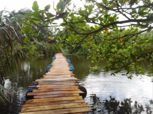 a wooden walkway in the middle of a body of water at Lagoon Beach Resort in Tangalle