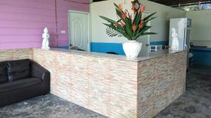 eine Lobby mit einer Theke, auf der eine Vase mit Blumen steht in der Unterkunft Sukorn Cabana Resort in Ko Sukon