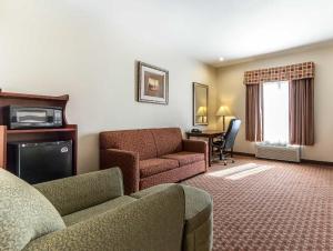 a living room with a couch and a chair and a table at Econo Lodge in Eutaw
