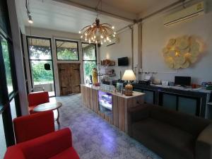 a living room with a kitchen with a table and chairs at Villa Gris Pranburi in Pran Buri