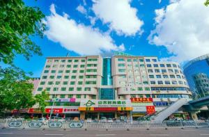 ein großes weißes Gebäude mit vielen Schildern darauf in der Unterkunft Zhaoqing Shanshui Fashion Hotel Duanzhou Road Branch in Zhaoqing