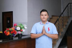 a man standing in a room with his hands at Metro Hotel in Surabaya