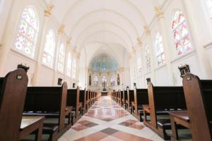an empty church with a row of benches and windows at Metro Hotel in Surabaya