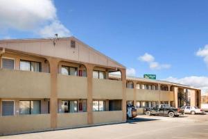 a building with cars parked in a parking lot at Quality Inn in Albuquerque