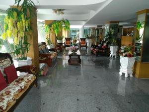a large living room with couches and plants at Diamond Sweet Hotel in Bangkok