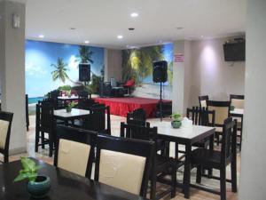 a dining room with tables and chairs and a stage at Flamengo Hotel in Gedeg