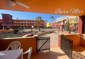 d'un balcon avec une clôture et quelques bâtiments. dans l'établissement BeiraMar La Caleta, piscina y wifi gratis, tranquilidad junto al atlántico, à Parque Holandes