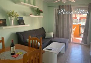 un salon avec une table et un canapé dans l'établissement BeiraMar La Caleta, piscina y wifi gratis, tranquilidad junto al atlántico, à Parque Holandes