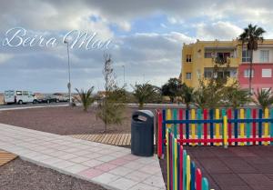 a colorful fence with a trash can next to a street at Beiramar La Caleta Fuerteventura, Piscina y wifi Gratis junto al Atlántico in Parque Holandes