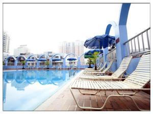 basen z leżakami i parasolem w obiekcie Noble Jasper Hotel Huizhou w mieście Huizhou