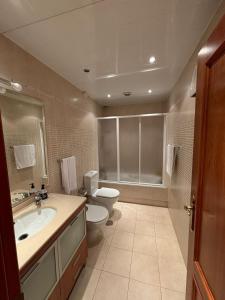 a bathroom with a toilet and a sink and a toilet istg at Piso de tres habitaciones frente al Puerto Deportivo in Viveiro