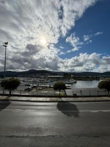 an empty street with a view of a body of water at Piso de tres habitaciones frente al Puerto Deportivo in Viveiro