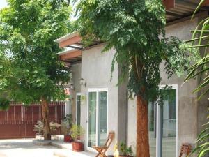a building with trees in front of it at Maesai Holic Lodge in Ban Pa Yang
