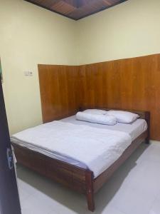a bed with a wooden headboard in a room at Raja Ampat Family Guest House in Saonek