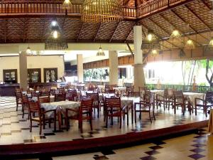 a dining room with tables and chairs in a building at Phuphaya Resort Pattaya in Pattaya South