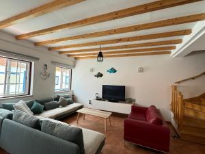 a living room with a couch and a tv at Porto Covo / Costa Alentejana in Porto Covo