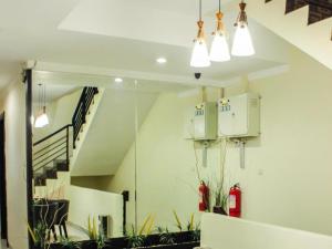 a room with a staircase with potted plants and lights at Vindhika Hotel in Makassar
