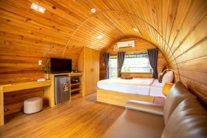 a bedroom with a large bed in a wooden room at Doan Gia Resort in Phong Nha