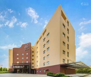 杭州Yitel Collection Hangzhou Binjiang Jiangnan Avenue Baolongcheng的酒店大楼的背景是天空