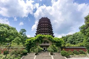 杭州Yitel Collection Hangzhou Binjiang Jiangnan Avenue Baolongcheng的一座高大的建筑,有楼梯通往