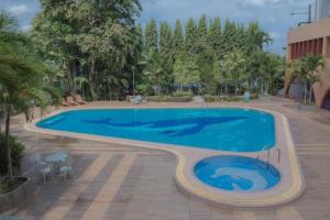 a large swimming pool in a courtyard with trees at Wangtai Hotel in Suratthani