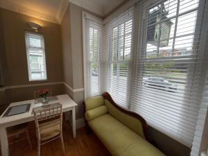 a living room with a couch and a table and windows at Central Hotel in Norwich +39 photos