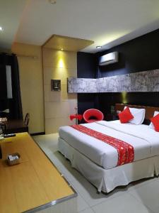um quarto com uma cama grande com travesseiros vermelhos em Queen City Hotel em Bugis