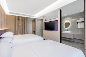 Un pat sau paturi într-o cameră la New Century Mansion Hotel Cixi Guanhaiwei