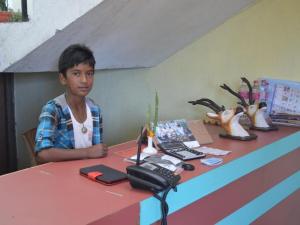 a young boy sitting at a table with a desk with a telephone at Mystique Highland Resort in Pokhara