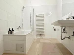 Baño blanco con lavabo y bañera en Close to Metro, 10 Minutes to Mariahilferstraße, en Viena
