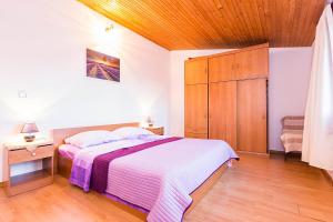 a bedroom with a bed and a wooden ceiling at Apartments Draga in Sukošan