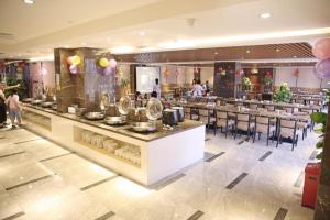 NanhaiにあるFoshan Xin Hu Hotelのテーブルと椅子のあるバーのあるレストラン