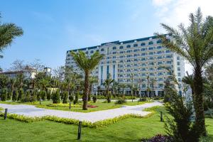 ein großes Gebäude mit Palmen in einem Park in der Unterkunft Paracel Resort Hai Tien in Mỹ Ðuc