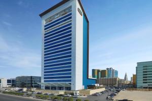 a tall building with blue windows in a city at Courtyard by Marriott Riyadh Olaya in Riyadh
