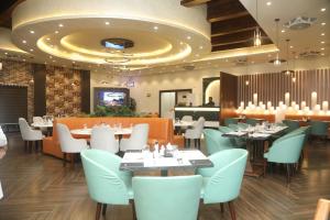 a restaurant with tables and chairs and a ceiling at Swarg Hotel in Sāhīwāl