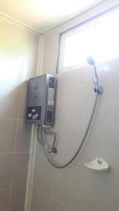 eine Dusche in einem Badezimmer mit einem Seifenspender an der Wand in der Unterkunft Jit Dee Home Khao Kho in Khao Kho